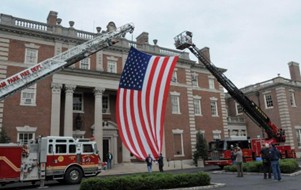 Fire Truck and Flag Suspended Between Ladders